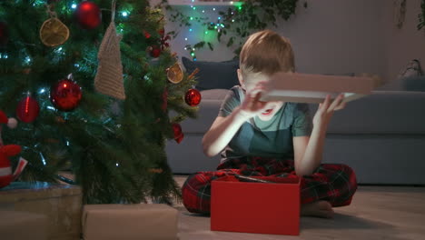 Entzückender-Dreijähriger-Junge-öffnet-Sein-Weihnachtsgeschenk-Und-Findet-Darin-Einen-Teddybären.-Hochwertiges-4K-Filmmaterial
